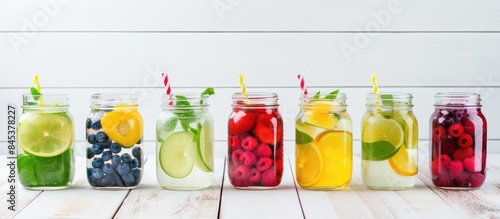 Fototapeta Naklejka Na Ścianę i Meble -  Infused flavored water with fresh fruits on white wooden background Refreshing summer homemade detox water. Creative banner. Copyspace image