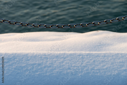 View of the snow-covered staircases and chain fence at the seaside photo