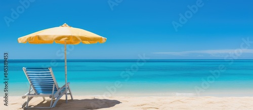 Outdoor with umbrella and chair on beautiful tropical beach and sea and blue sky background. Creative banner. Copyspace image
