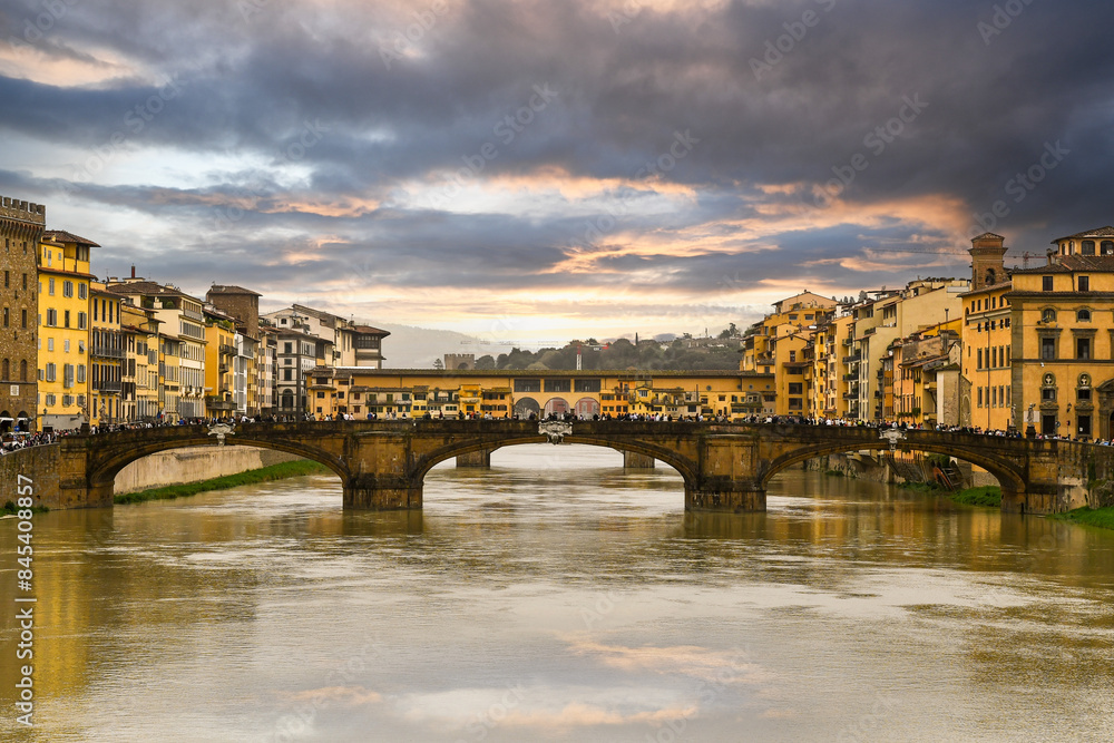 Obraz premium Dramatic sunset on the Arno River with the Ponte Santa Trinita and the Ponte Vecchio in the background, that connect the two sides of the historic centre of Florence, Tuscany, Italy