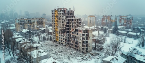 : Aerial view of bombed residential building with snow in winter during the war between Russia and Ukraine. © AR99