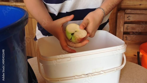 A person is holding an apple in a white container