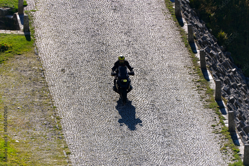 Fototapeta premium Scenic view of mountain pass road named Tremola with motorcyclist way up at Swiss mountain pass Gotthard on a sunny late summer day. Photo taken September 10th, 2023, Gotthard, Switzerland.