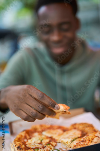 Close Up Of Teenage Boy Eating Pizza At Outdoor Street Food Market
