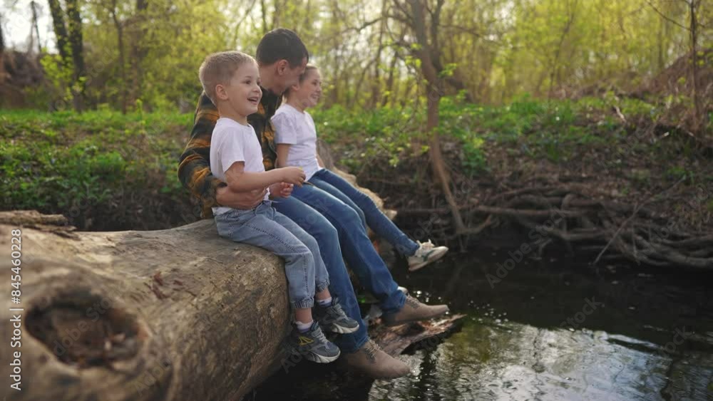 dad with children sits on a log. happy family child dream concept ...