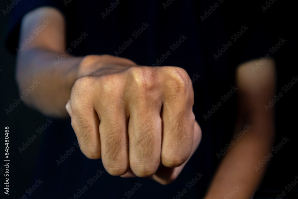 Man with a gesture of clenching his fists forward on dark background. Violence concept. Man with a gesture of clenching his fists forward on dark background. Violence concept.