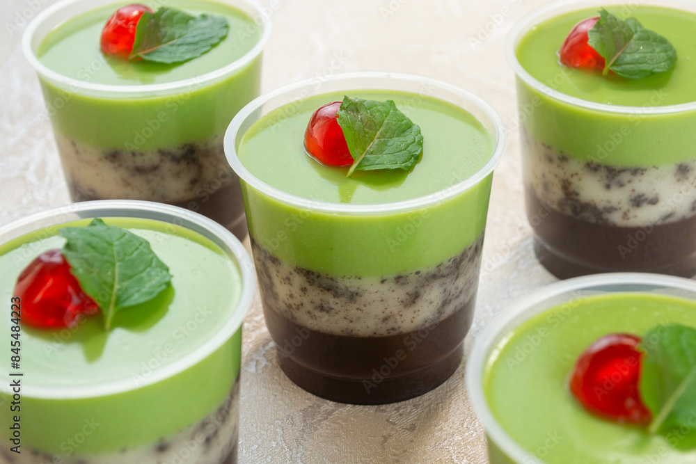puding lapis alpukat or avocado layer pudding. topped with cherry pieces and mint leaves. Very fresh and healthy puding lapis alpukat or avocado layer pudding. topped with cherry pieces and mint leaves. Very fresh and healthy