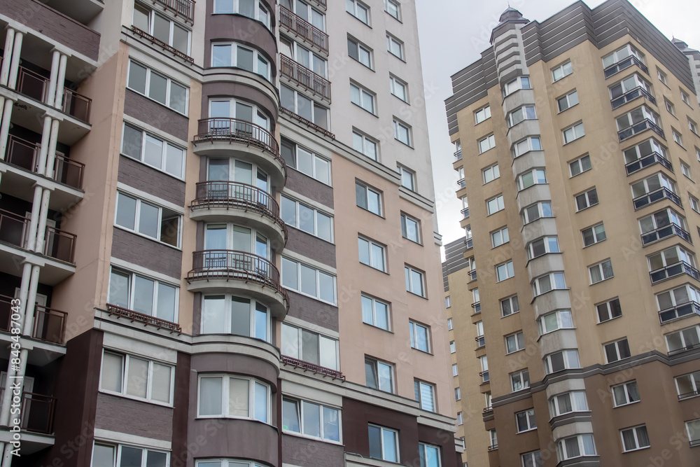 A tall building with many windows and balconies in the city during the day A tall building with many windows and balconies in the city during the day