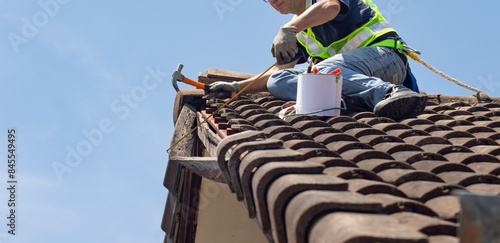 Wallpaper Mural Worker man repairing eaves and tile of the old roof.. Torontodigital.ca