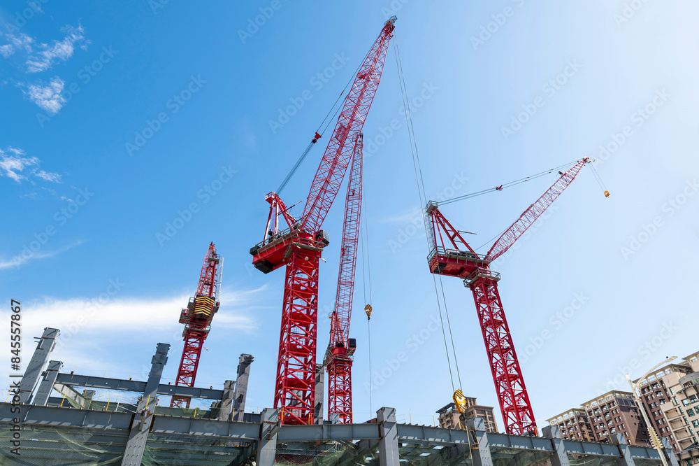 Cranes and steel structures of building construction with a blue sky background. Cranes and steel structures of building construction with a blue sky background.