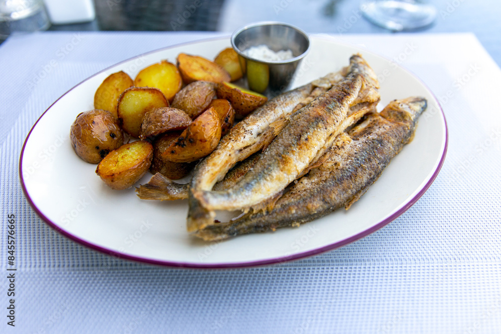 Fried smelt with boiled potatoes and mushroom sauce on a white plate. Delicious rustic lunch Fried smelt with boiled potatoes and mushroom sauce on a white plate. Delicious rustic lunch