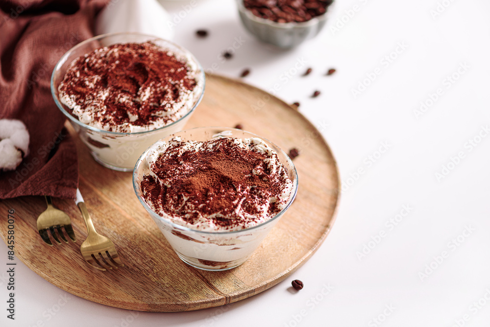 Traditional Italian dessert tiramisu in glasses on white table. Soft focus Traditional Italian dessert tiramisu in glasses on white table. Soft focus