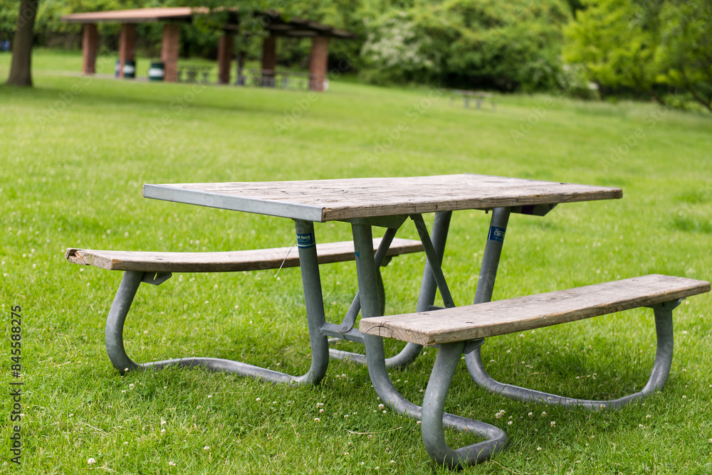 Park Picnic table bench rest relax outdoors. Benches and tables on green grass in recreational area. Park Picnic table bench rest relax outdoors. Benches and tables on green grass in recreational area.