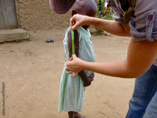 Konstfotografi Woman measuring a little girls arm to check for malnutrition