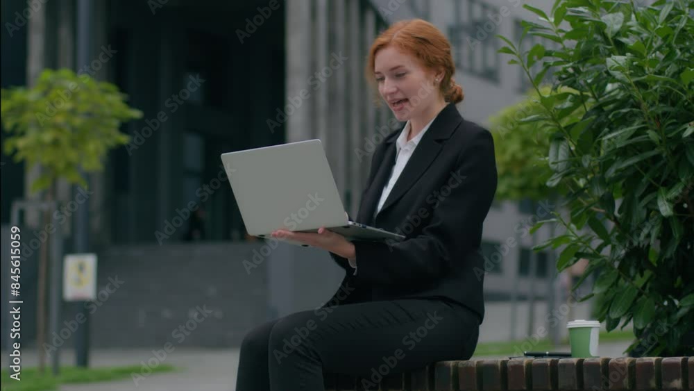 Happy Caucasian female businesswoman girl client woman ginger student freelancer formal suit sitting talking online business meeting wireless video call talk laptop notebook outside city urban street