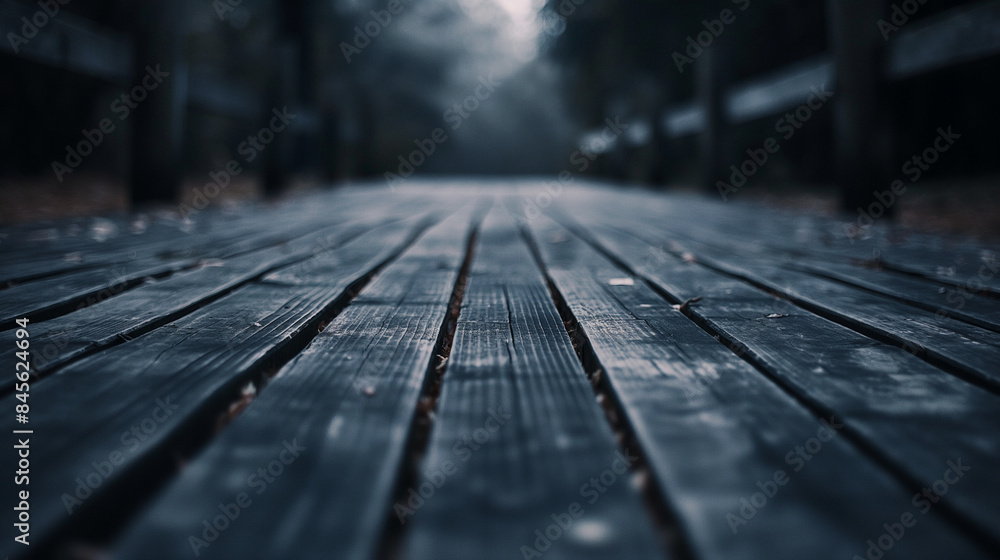 The perspective of a wooden boardwalk draws the viewer into a mysterious and moody forest setting The perspective of a wooden boardwalk draws the viewer into a mysterious and moody forest setting