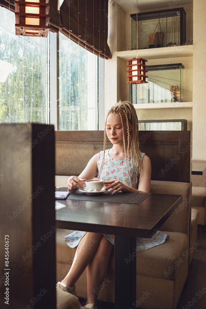 Cute girl with dreadlocks drinks coffee. Cute girl with dreadlocks drinks coffee.