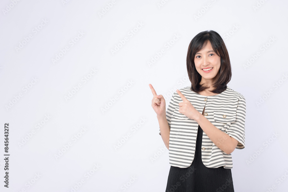 A Young asian woman pointing finger to free copy space isolated on white studio background A Young asian woman pointing finger to free copy space isolated on white studio background
