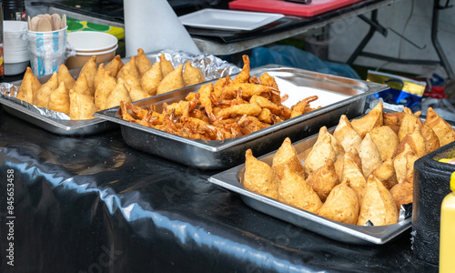 Fried Asian snacks on display, featuring crispy onion rings, tempura shrimp, and assorted dumplings