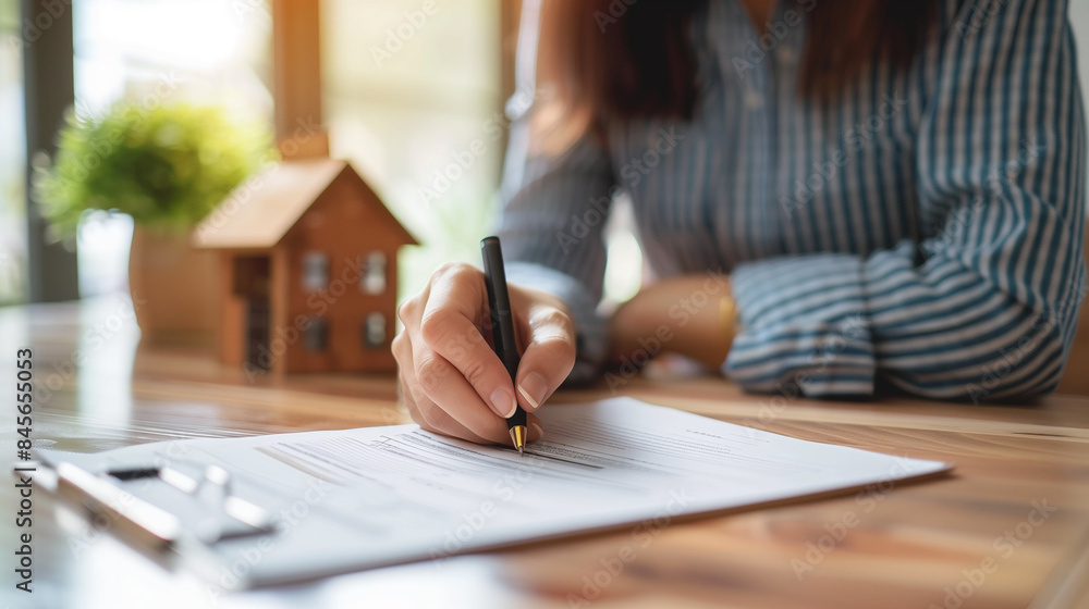 An individual signing documents related to real estate transactions, emphasizing the importance of contracts and agreements in the property market. An individual signing documents related to real estate transactions, emphasizing the importance of contracts and agreements in the property market.