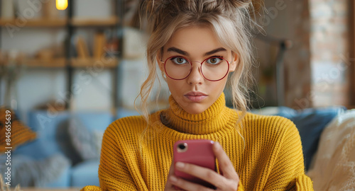 Young Woman in Yellow Sweater Uses Smartphone in Indoor Setting