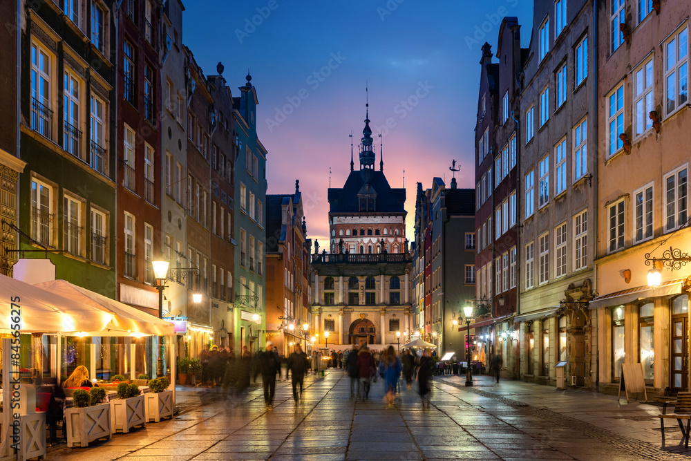 Fototapeta premium Golden Gate to the old town of Gdansk at night, Poland. Panoramic evening view, long exposure, timelapse. Historical city of Gdansk (Danzig) , Poland, Europe.