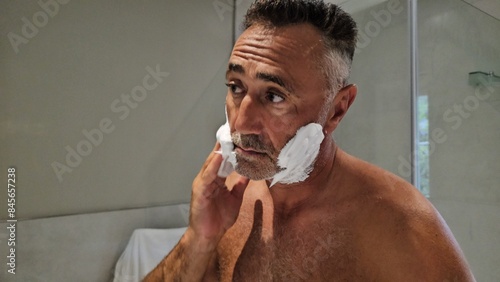 Man Shaving in Front of a Mirror