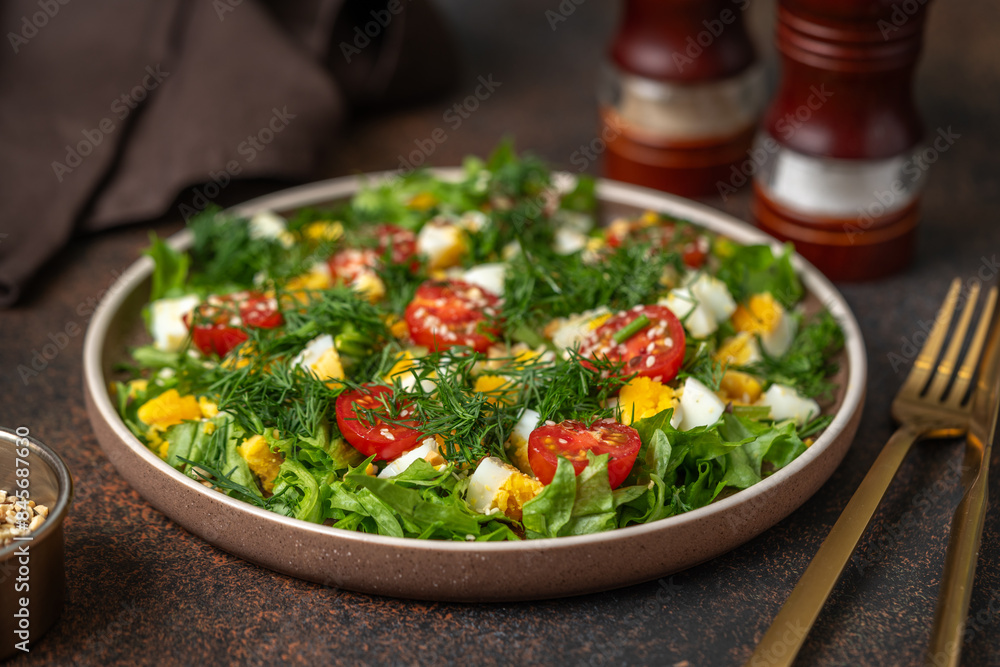 Salad with eggs, cherry tomatoes, dill, lettuce leaves and olive oil. Food for weight loss closeup