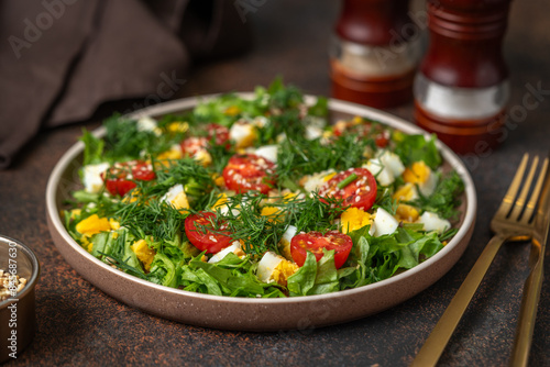 Salad with eggs, cherry tomatoes, dill, lettuce leaves and olive oil. Food for weight loss closeup