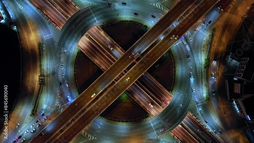 Financial technology, energy power, beautiful top view time-lapse of car traffic at roundabout lane and buildings. 4K drone aerial zoom out. Urban cityscape concept or abstract of advanced innovation.
