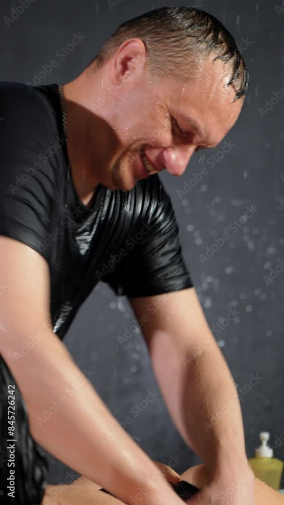 Smiling handsome male masseur massages woman body in aqua zone, vertical video. Man masseur strokes female body with strong hands during massage. Drops of water run down face Smiling handsome male masseur massages woman body in aqua zone, vertical video. Man masseur strokes female body with strong hands during massage. Drops of water run down face