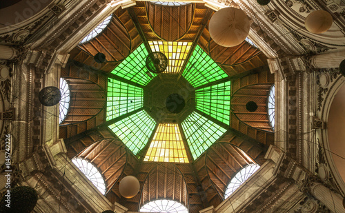 Bottom view of the ceiling of an antique building with a glass dome.