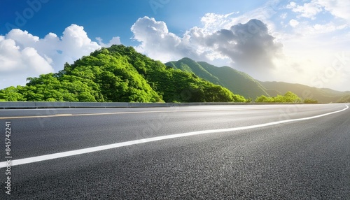 Asphalt road and green mountain with sky clouds natural background on sunny day 