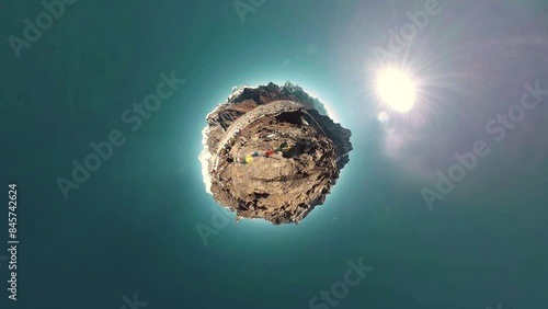 Gokyo Ri mountain top. Tibetan prayer Buddhist flag. Wild Himalayas high altitude nature and mount valley. Rocky slopes covered with ice. Little planet transformation movement