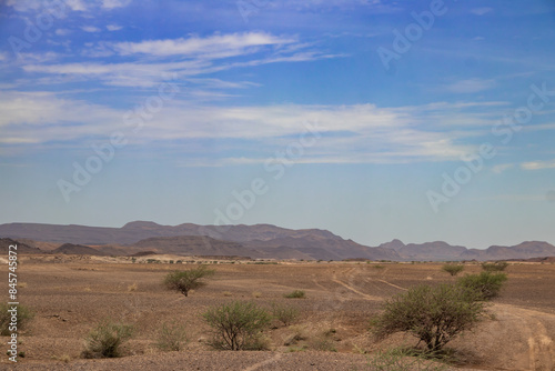 Dry open countryside and low hills beneath a broad sky
