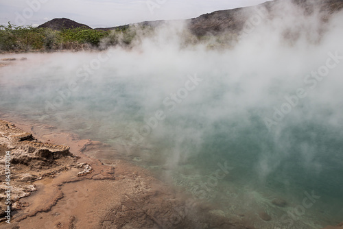 Alolabad geothermal area in Ethiopia with surreal landscape of colorful hot springs, steaming fumaroles, and erupting salt geysers in an arid, remote desert setting below sea level, Afar desert. photo