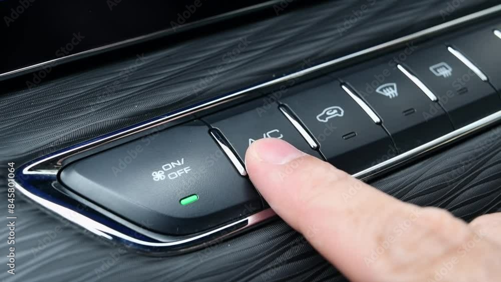 Man presses his finger on the button to turn on the air conditioner in the car. Turning on the air conditioner in a car.