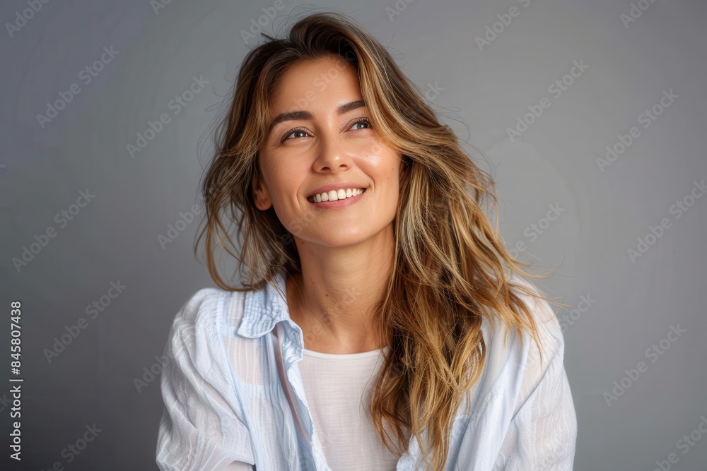 Stunning woman with a carefree smile looking away in a light-hearted pose Stunning woman with a carefree smile looking away in a light-hearted pose