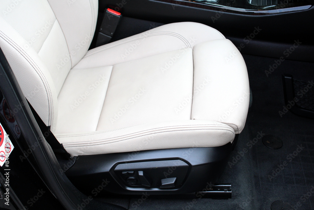 Obraz premium Light leather Driver seat of a new modern car. Beige Leather car interior. White leather drivers seat in a car. Front seats of a modern passenger car. 