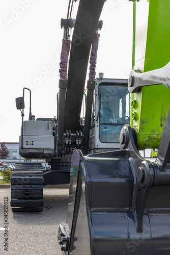 A modern excavator equipped with hydraulic attachments, such as buckets and breakers, efficiently digs trenches, demolishes structures, and handles materials