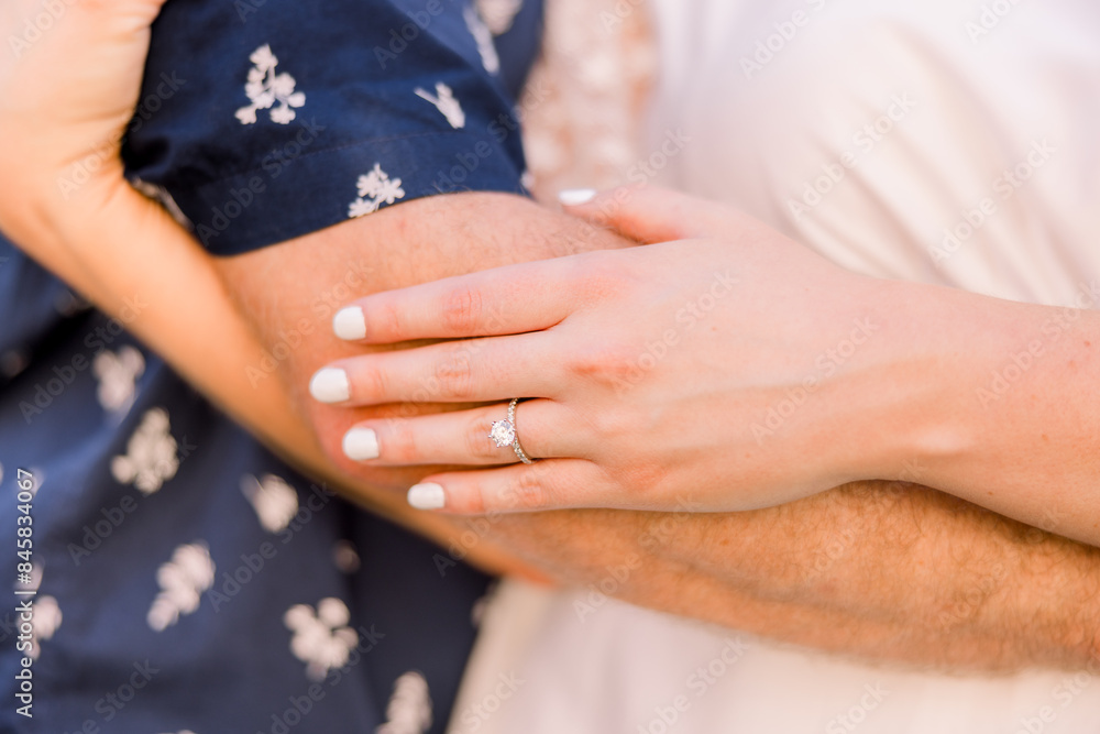 A couple is embracing, and she has her hands on his arm. A couple is embracing, and she has her hands on his arm.
