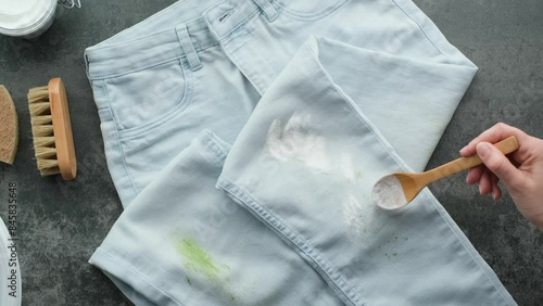 Homemade eco-friendly removing of stains on clothes with baking soda. Woman's hand applies baking soda powder for eco-friendly stain removal. Zero waste concept. 4k video