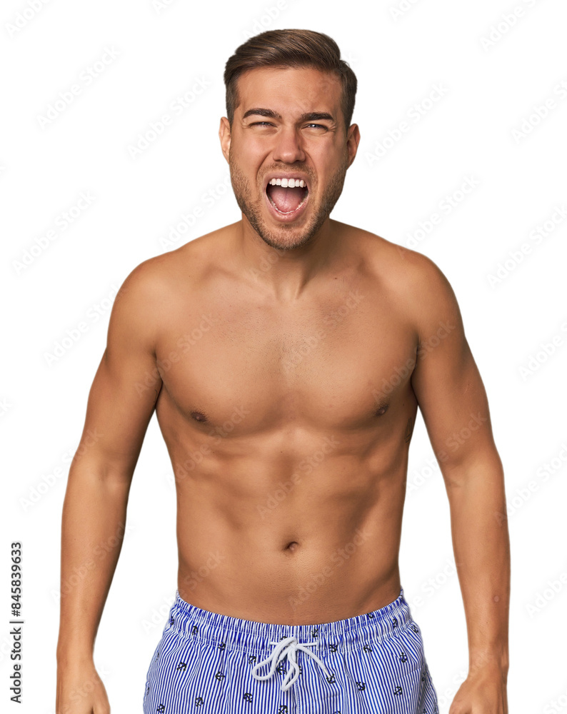 Young man shirtless in swimwear, studio screaming very angry and aggressive. Young man shirtless in swimwear, studio screaming very angry and aggressive.