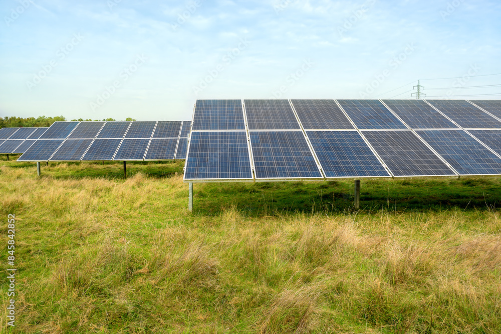 Many solar panels are installed in Germany on a country field where green grass grows. Green energy concept. Concept of using solar energy. Many solar panels are installed in Germany on a country field where green grass grows. Green energy concept. Concept of using solar energy.