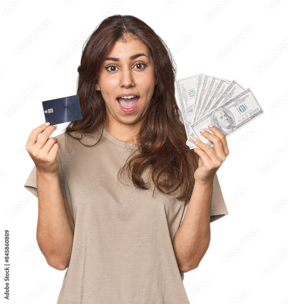 Young Middle Eastern woman comparing credit card and dollars in studio Young Middle Eastern woman comparing credit card and dollars in studio