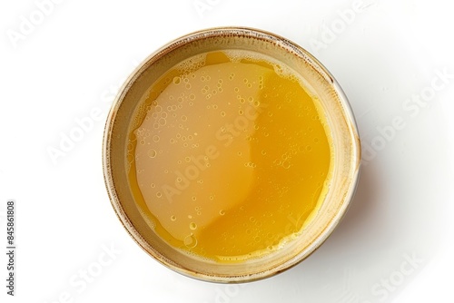 Top view of isolated fresh chicken broth in a bowl on white background