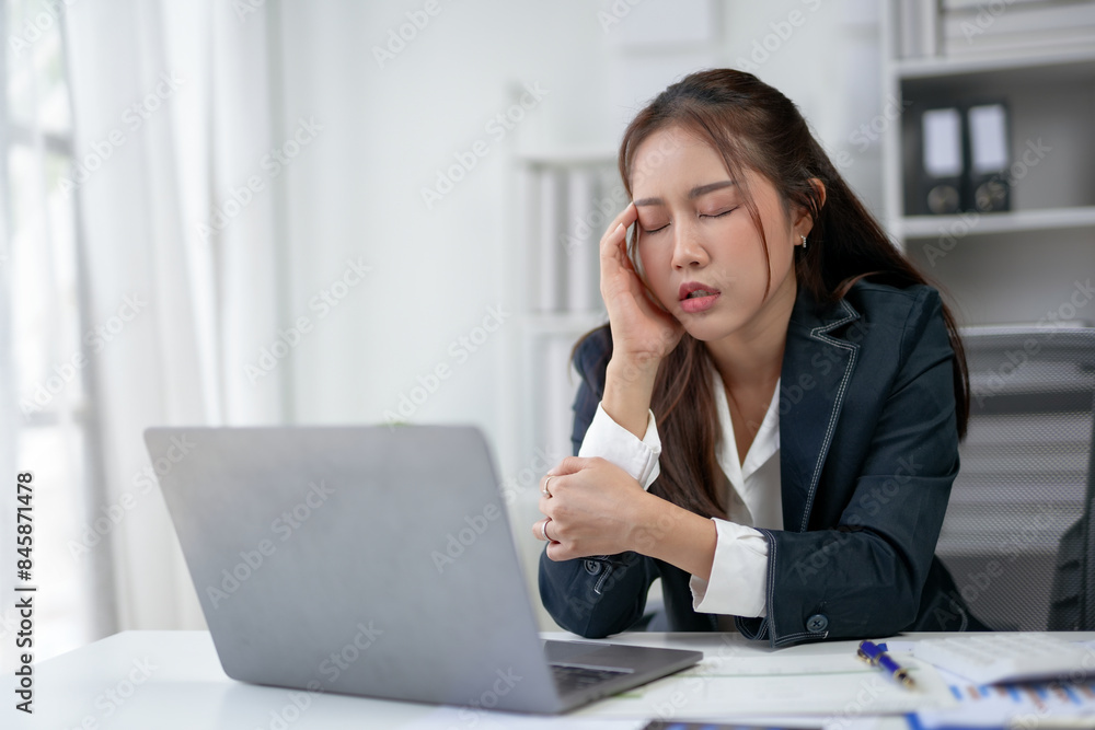 Tired businesswoman sitting at desk with laptop, showing exhaustion and fatigue at the workplace. Overworked and stressed professional. Tired businesswoman sitting at desk with laptop, showing exhaustion and fatigue at the workplace. Overworked and stressed professional.