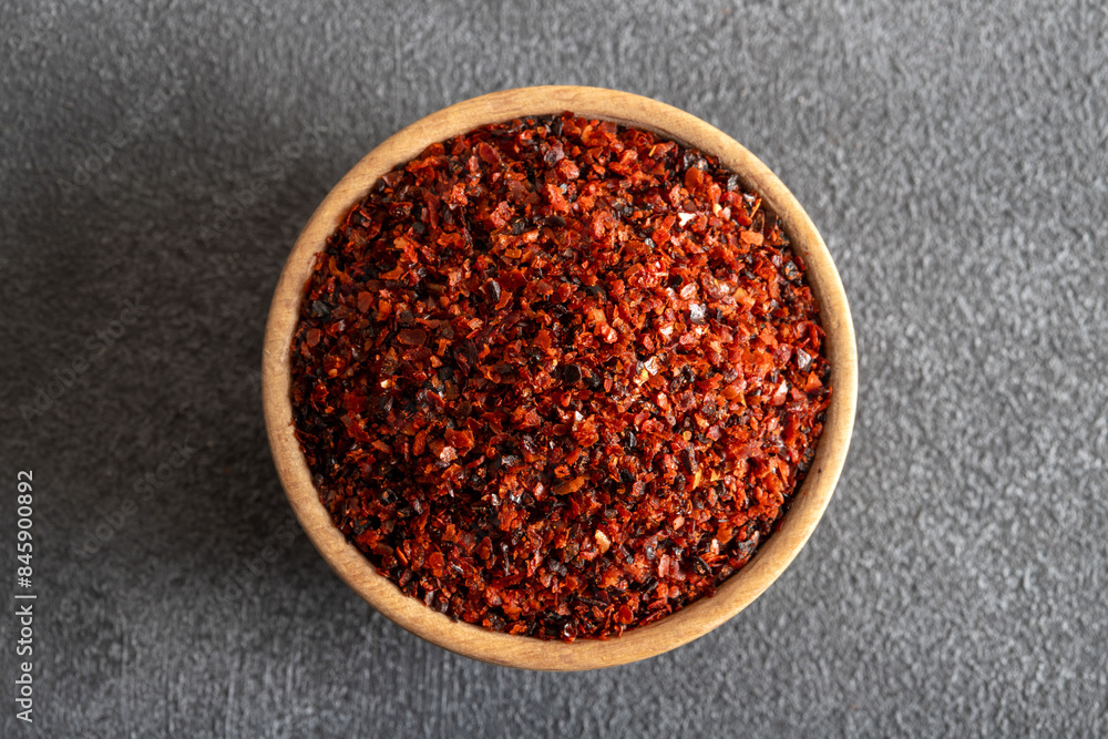 Red pepper flakes.Red chili peppers in wooden bowl on black background
Red pepper flakes.Red chili peppers in wooden bowl on black background