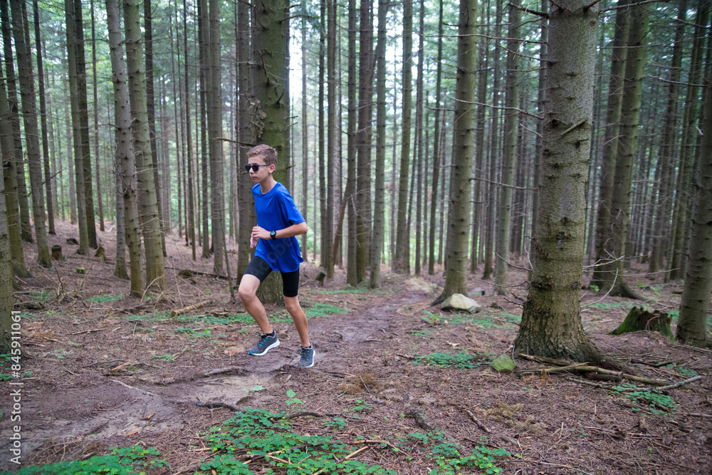 A guy is running in the forest. A guy is running in the forest.