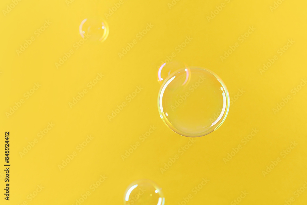 Beautiful transparent soap bubbles on yellow background Beautiful transparent soap bubbles on yellow background
